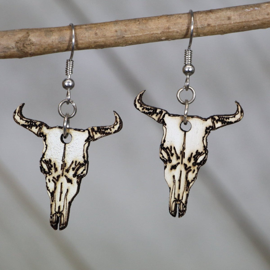 Hand-painted wooden cow skull dangle earrings with western boho desert design and hypoallergenic sterling silver hooks, lightweight cow skull statement jewelry earrings for southwestern style