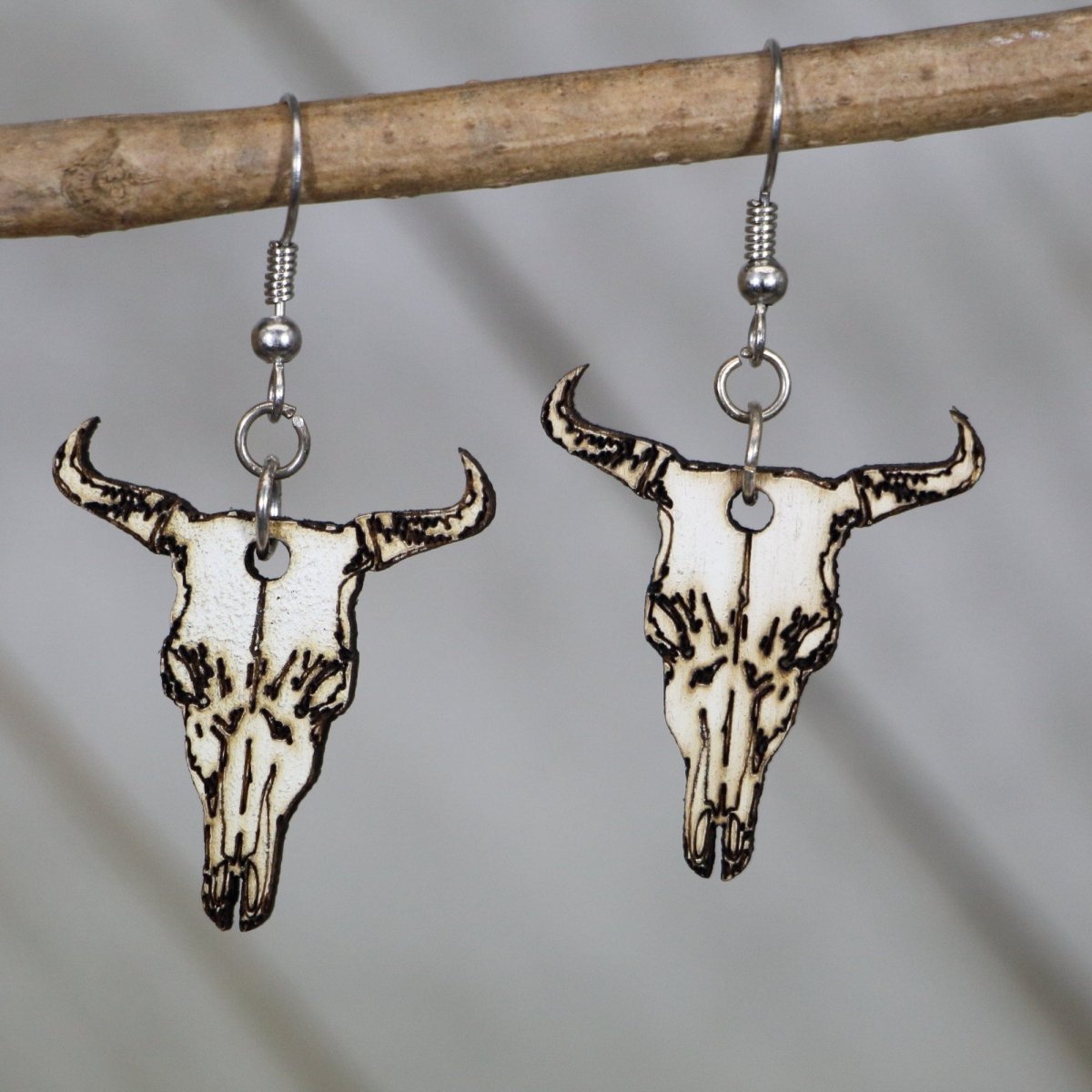 Hand-painted wooden cow skull dangle earrings with western boho desert design and hypoallergenic sterling silver hooks, lightweight cow skull statement jewelry earrings for southwestern style