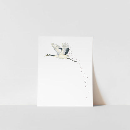 A art print of a Japanese crane with a blossom in its beak, printed on ultra premium matte paper with archival inks, signed by Heather S Vitticore.