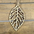 Hand-painted wooden cutout leaf Christmas ornament featuring an intricate nature-inspired leaf silhouette with detailed vein cutouts, elegant holiday decor for nature lovers and botanical enthusiasts by Cate’s Concepts
