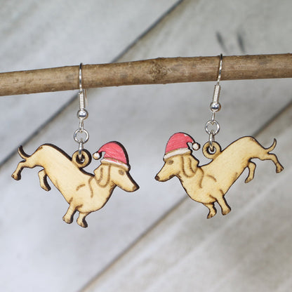 Hand-painted wooden dachshund Santa hat dangle earrings featuring a long-bodied wiener dog design wearing a festive Santa hat and hypoallergenic sterling silver hooks, lightweight jewelry for dog lovers and Christmas enthusiasts
