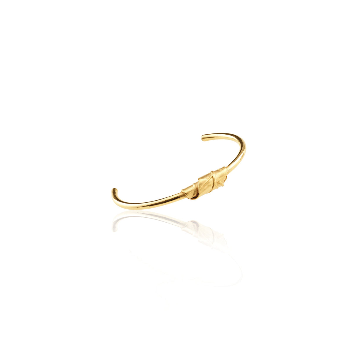 Sculptural wrapped leaf on simple gold bangle, made by hand, flat lay