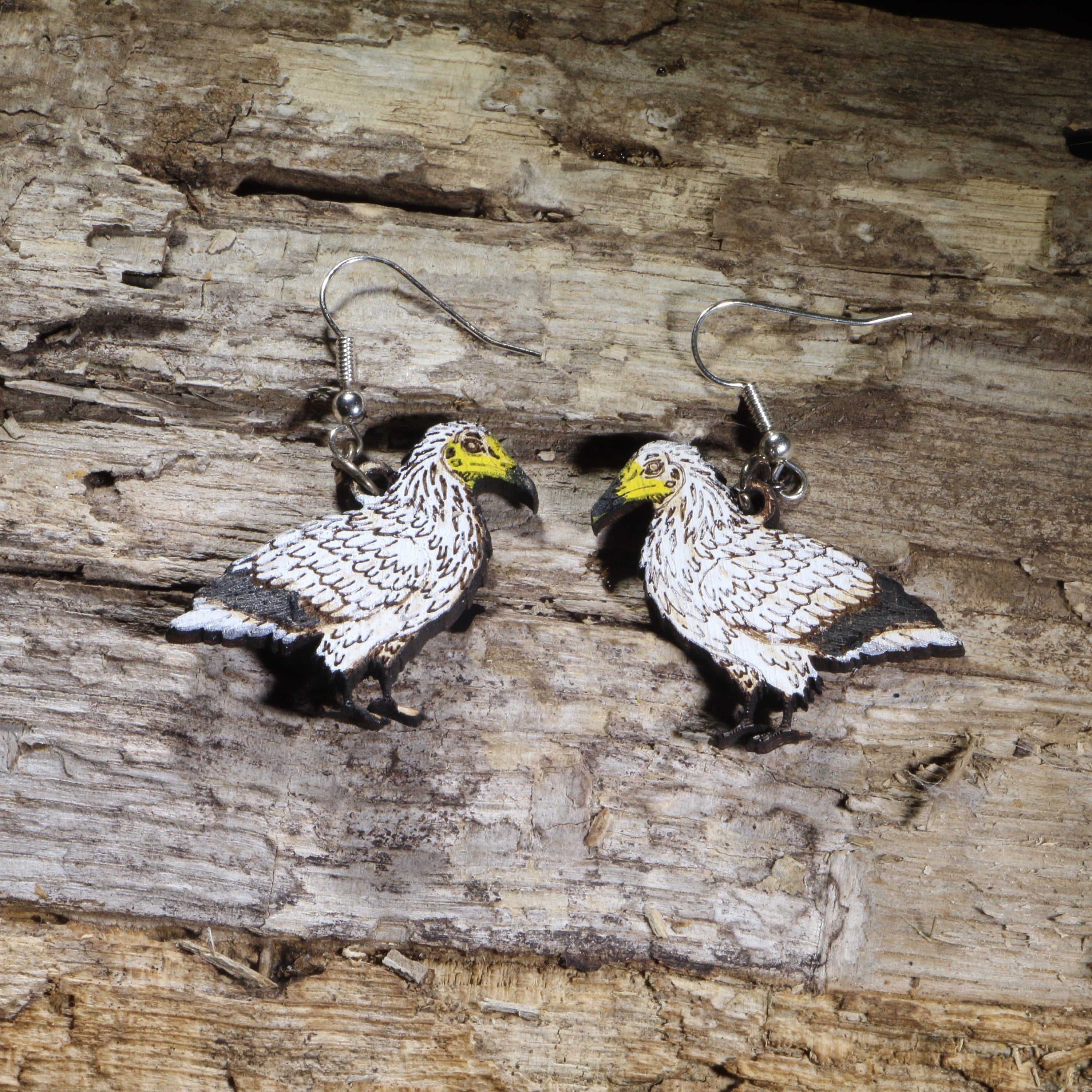 Hand-painted Egyptian vulture wooden dangle earrings on hypoallergenic .925 sterling silver hooks. Lightweight wildlife bird jewelry for birdwatchers, ornithologists, raptor enthusiasts, conservation supporters, and nature lovers.