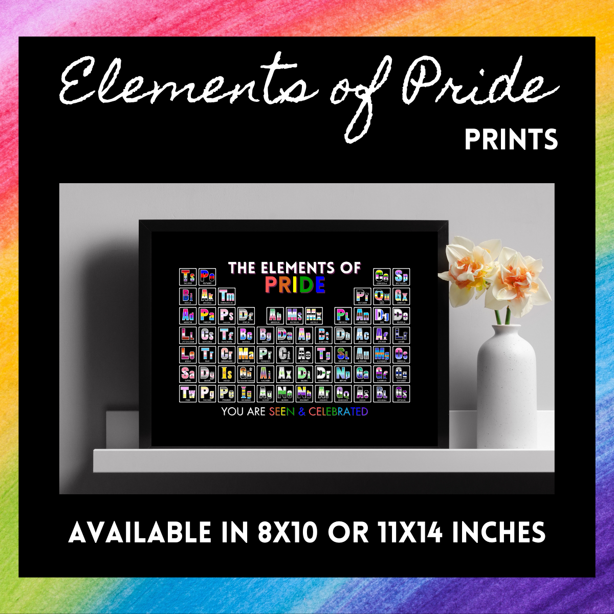 At the center of the image is our Elements of Pride Periodic Table. You can purchase them in 8x10 or 11x14 inches. The print is sitting on a white shelf with a vase with yellow flowers. 