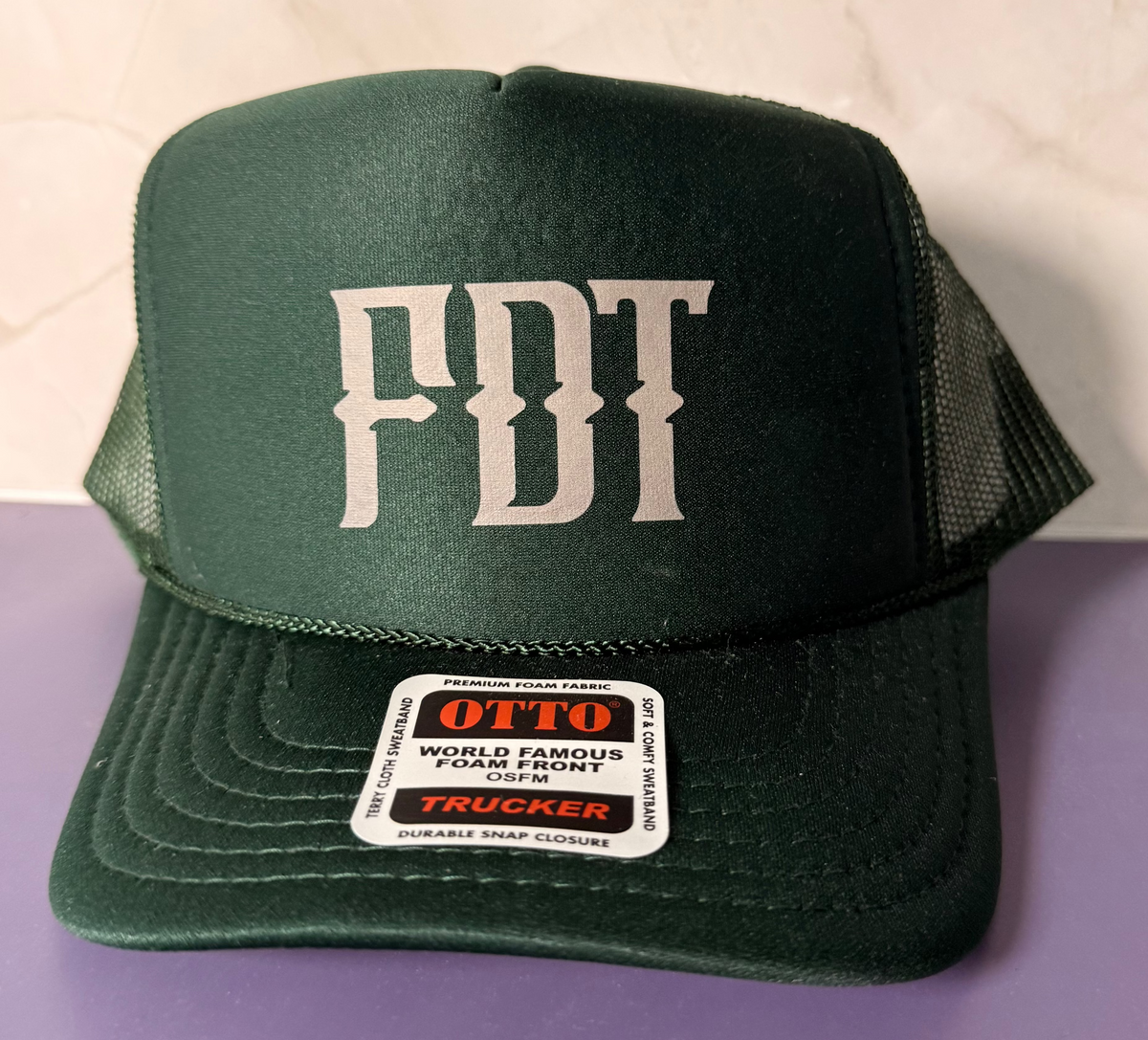 A dark green trucker hat with &