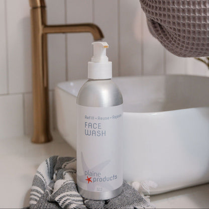 Bottle of natural vitamin c face wash on a bathroom counter in a plastic free aluminum bottle. 