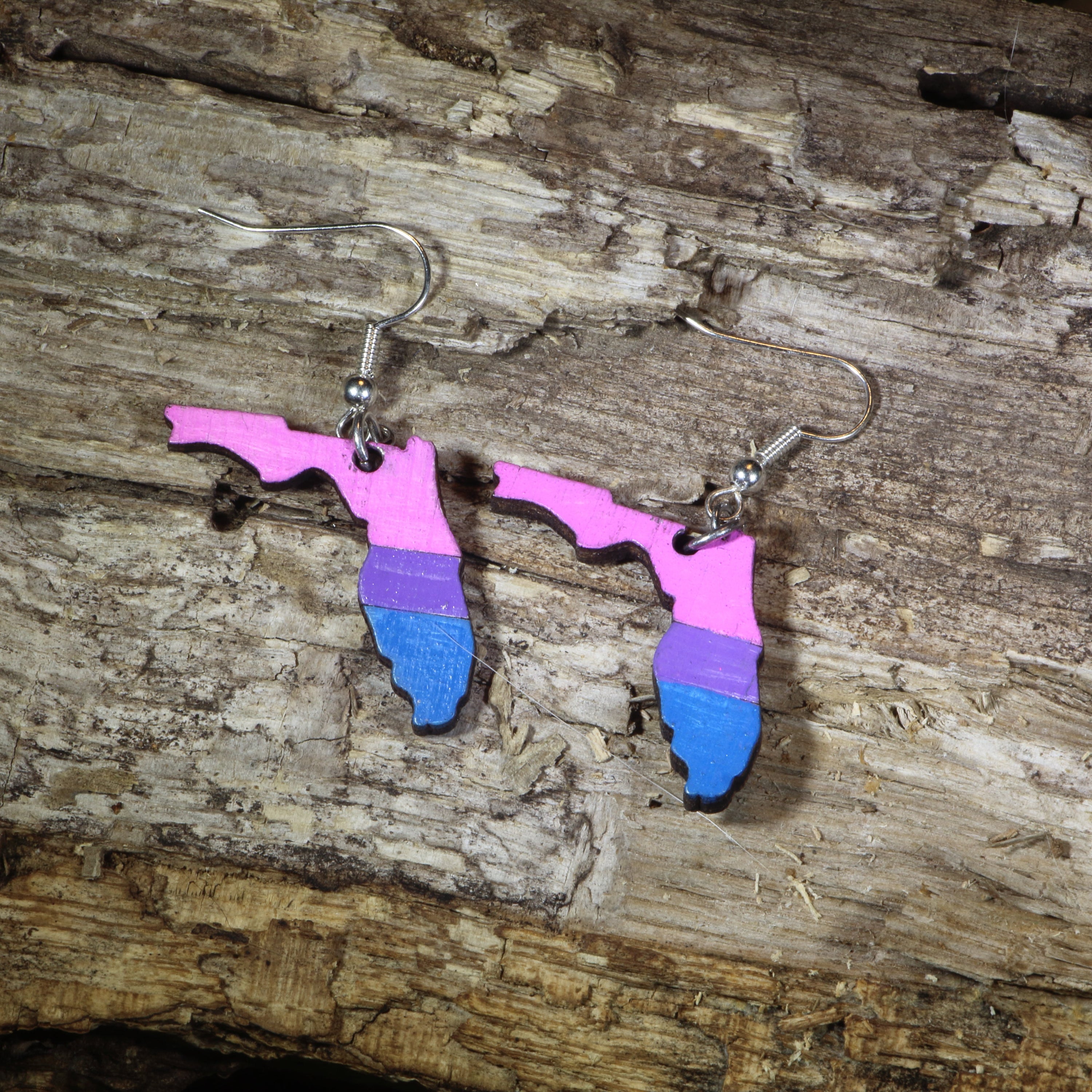 Hand-painted wooden Florida bisexual pride dangle earrings featuring the Florida state silhouette in pink, purple, and blue bisexual pride stripes, hypoallergenic sterling silver hooks, and lightweight LGBTQ+ state pride jewelry by Cate&