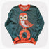 A green graphic knit sweater with an owl standing on the letter O design.