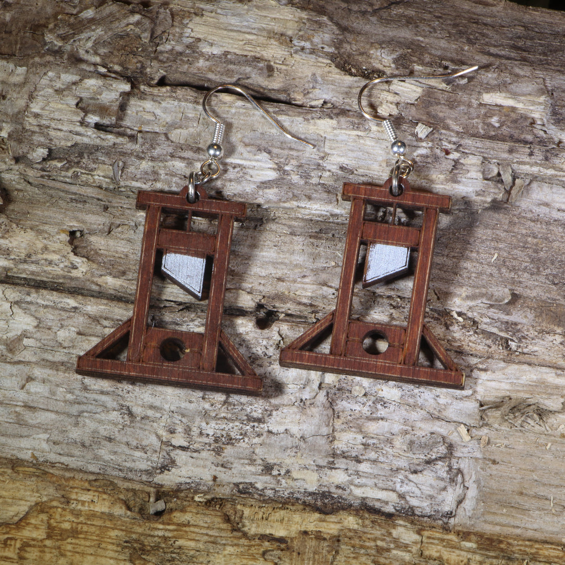 Hand-painted wooden guillotine dangle earrings featuring a detailed French Revolution guillotine design, hypoallergenic sterling silver hooks, and lightweight historical jewelry for history buffs, gothic fashion, and dark humor lovers by Cate’s Concepts.