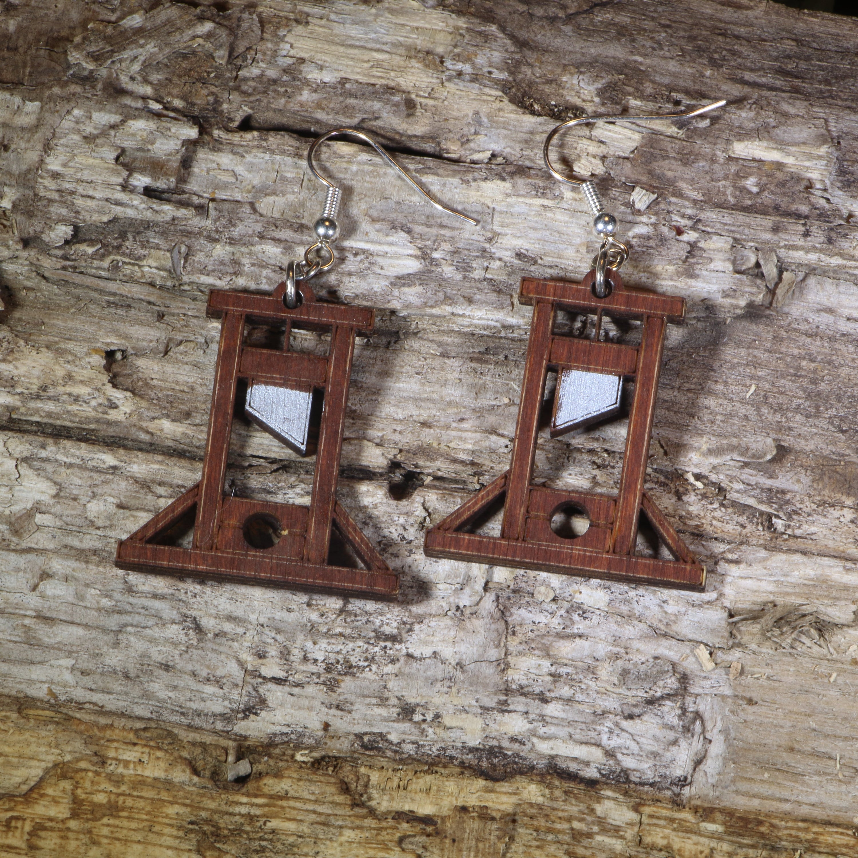 Hand-painted wooden guillotine dangle earrings featuring a detailed French Revolution guillotine design, hypoallergenic sterling silver hooks, and lightweight historical jewelry for history buffs, gothic fashion, and dark humor lovers by Cate’s Concepts.