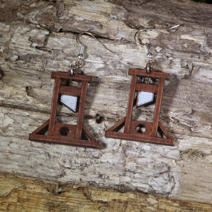 Hand-painted wooden guillotine dangle earrings featuring a detailed French Revolution guillotine design, hypoallergenic sterling silver hooks, and lightweight historical jewelry for history buffs, gothic fashion, and dark humor lovers by Cate’s Concepts.