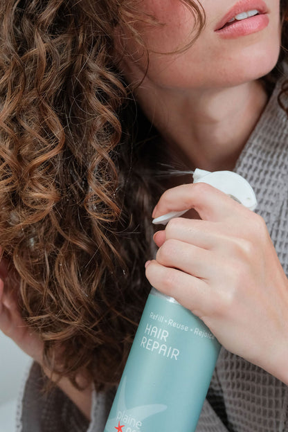 Person using natural Hair Repair product on their curly hair to revitalize and refresh curls