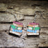 Hand-painted book stack wooden dangle earrings featuring a colorful pile of classic books. Lightweight literary jewelry perfect for librarians, teachers, readers, book lovers, writers, and thoughtful bookish gifts.