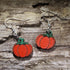 Hand-painted pumpkin wooden dangle earrings featuring a bright orange pumpkin with a green stem. Lightweight fall earrings perfect for pumpkin lovers, Thanksgiving, harvest festivals, autumn outfits, and seasonal fall jewelry.