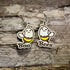 Hand-painted wooden "Boo Bees" dangle earrings featuring adorable smiling ghost bees with yellow stripes and the playful "Boo Bees" pun on hypoallergenic .925 sterling silver hooks. Lightweight Halloween jewelry for bee lovers, ghost fans, fall festivals, spooky season, and anyone who enjoys cute Halloween accessories.