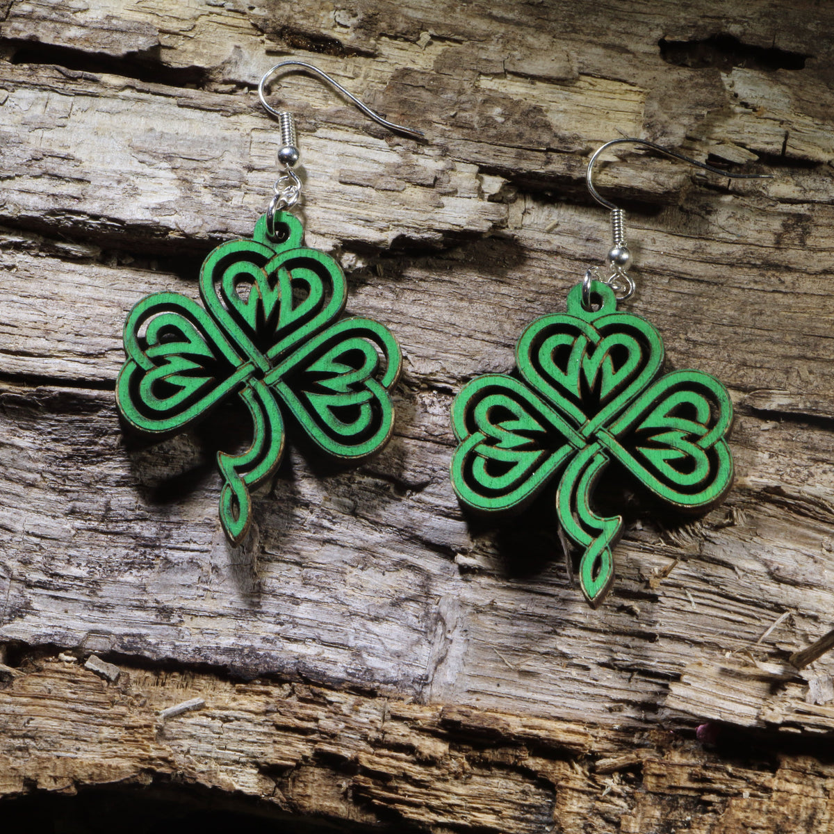 Hand-painted wooden Celtic knot shamrock dangle earrings featuring an intricate four-leaf shamrock inspired by traditional Celtic knotwork. Lightweight wooden earrings with hypoallergenic .925 sterling silver hooks, perfect for St. Patrick&