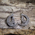 Hand-painted wooden Celtic wolf dangle earrings featuring an intricately detailed howling wolf within a Celtic knot crescent moon on hypoallergenic .925 sterling silver hooks. Lightweight Celtic jewelry for wolf lovers, pagan and Wiccan enthusiasts, nature lovers, mythology fans, and admirers of Celtic art and folklore.
