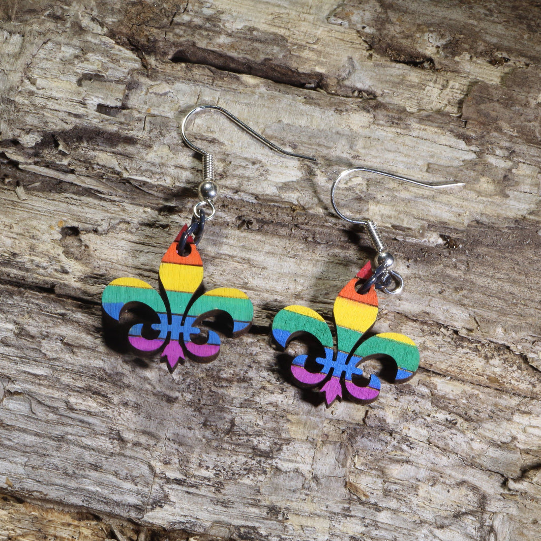 Hand-painted wooden LGBTQ+ Pride fleur-de-lis dangle earrings featuring the iconic fleur-de-lis symbol in rainbow pride colors on hypoallergenic .925 sterling silver hooks. Lightweight New Orleans–inspired jewelry celebrating LGBTQ+ pride, equality, and Louisiana culture.