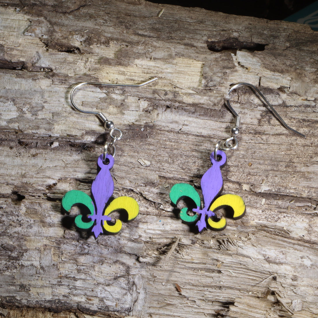 Hand-painted wooden Mardi Gras fleur-de-lis dangle earrings featuring the iconic fleur-de-lis in traditional purple, green, and gold colors on hypoallergenic .925 sterling silver hooks. Lightweight New Orleans jewelry for Mardi Gras celebrations, Louisiana culture, festival wear, and fleur-de-lis lovers.