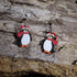 Hand-painted wooden Santa penguin dangle earrings featuring an adorable penguin dressed in a festive Santa hat. Lightweight Christmas earrings with hypoallergenic .925 sterling silver hooks, perfect for holiday parties, winter celebrations, stocking stuffers, penguin lovers, and festive seasonal outfits.