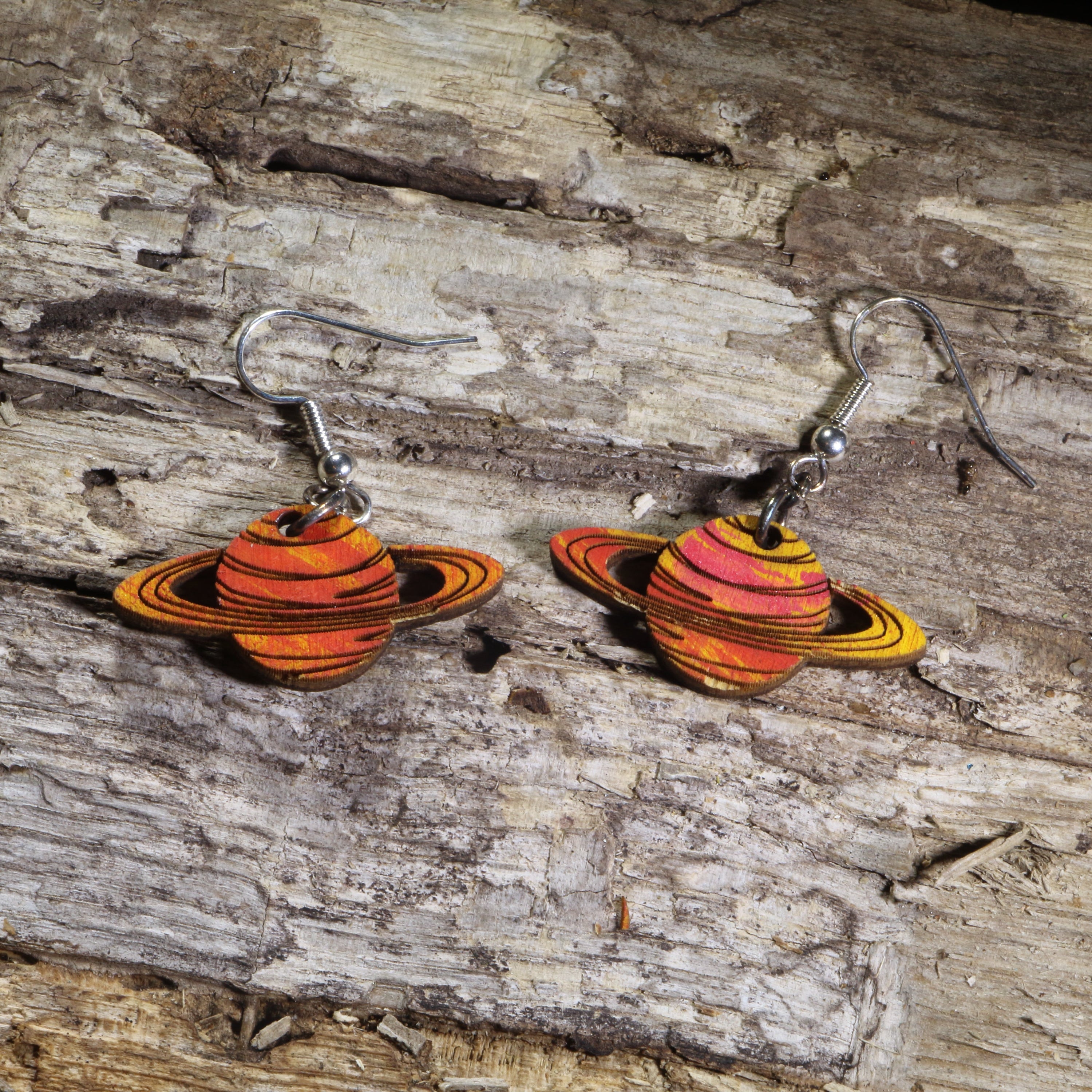 Hand-painted wooden Saturn planet dangle earrings featuring orange and gold striped rings on hypoallergenic .925 sterling silver hooks. Lightweight space-inspired jewelry for astronomy enthusiasts, science teachers, stargazers, NASA fans, and lovers of the solar system.