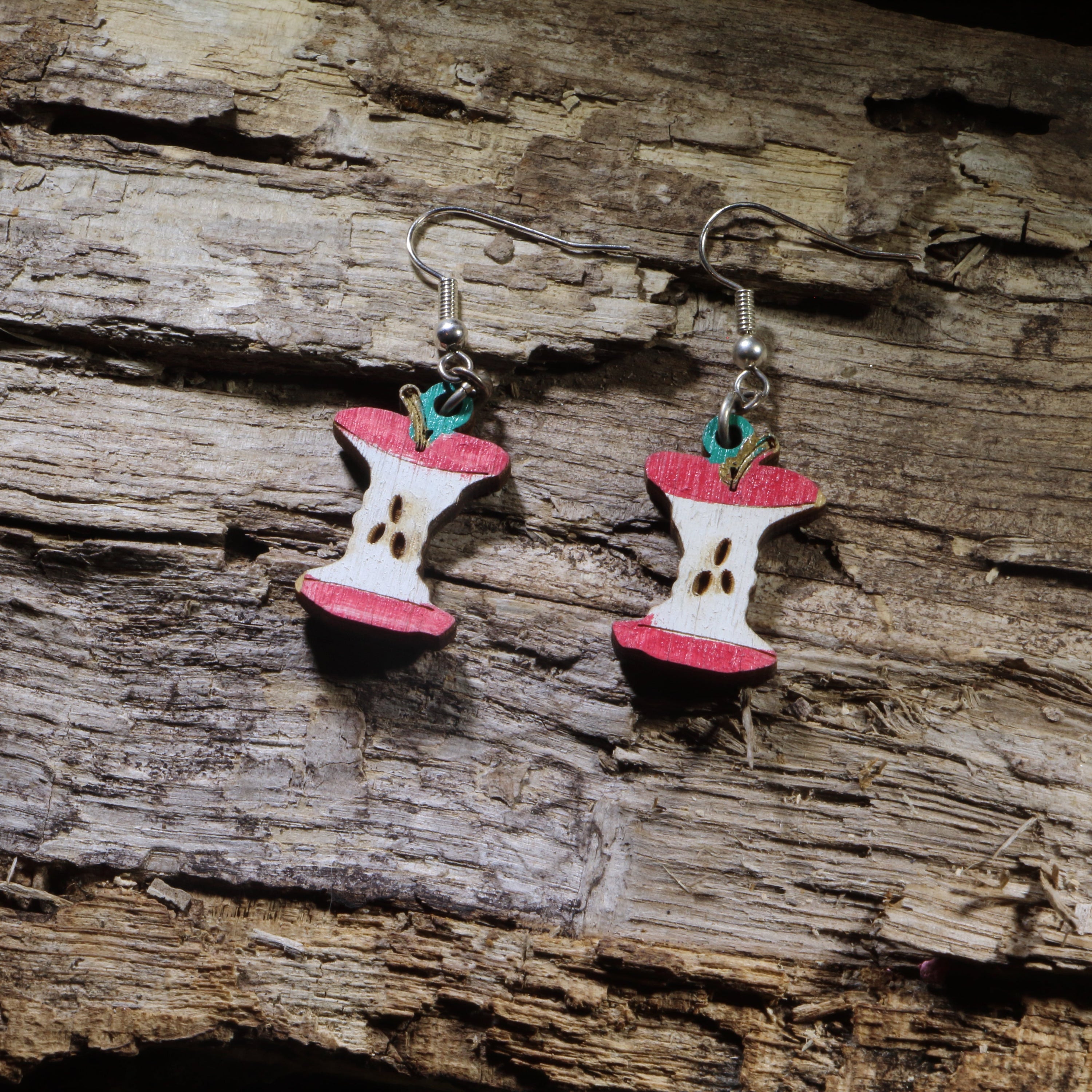 Hand-painted wooden apple core dangle earrings on hypoallergenic .925 sterling silver hooks. Lightweight teacher and fruit-inspired jewelry for educators, school staff, apple lovers, and anyone with a playful sense of humor.