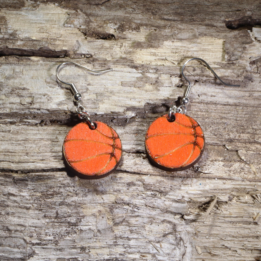 Hand-painted wooden basketball dangle earrings featuring bright orange basketballs with engraved court line details on hypoallergenic .925 sterling silver hooks. Lightweight basketball jewelry for players, coaches, referees, basketball moms, sports fans, and team spirit accessories.