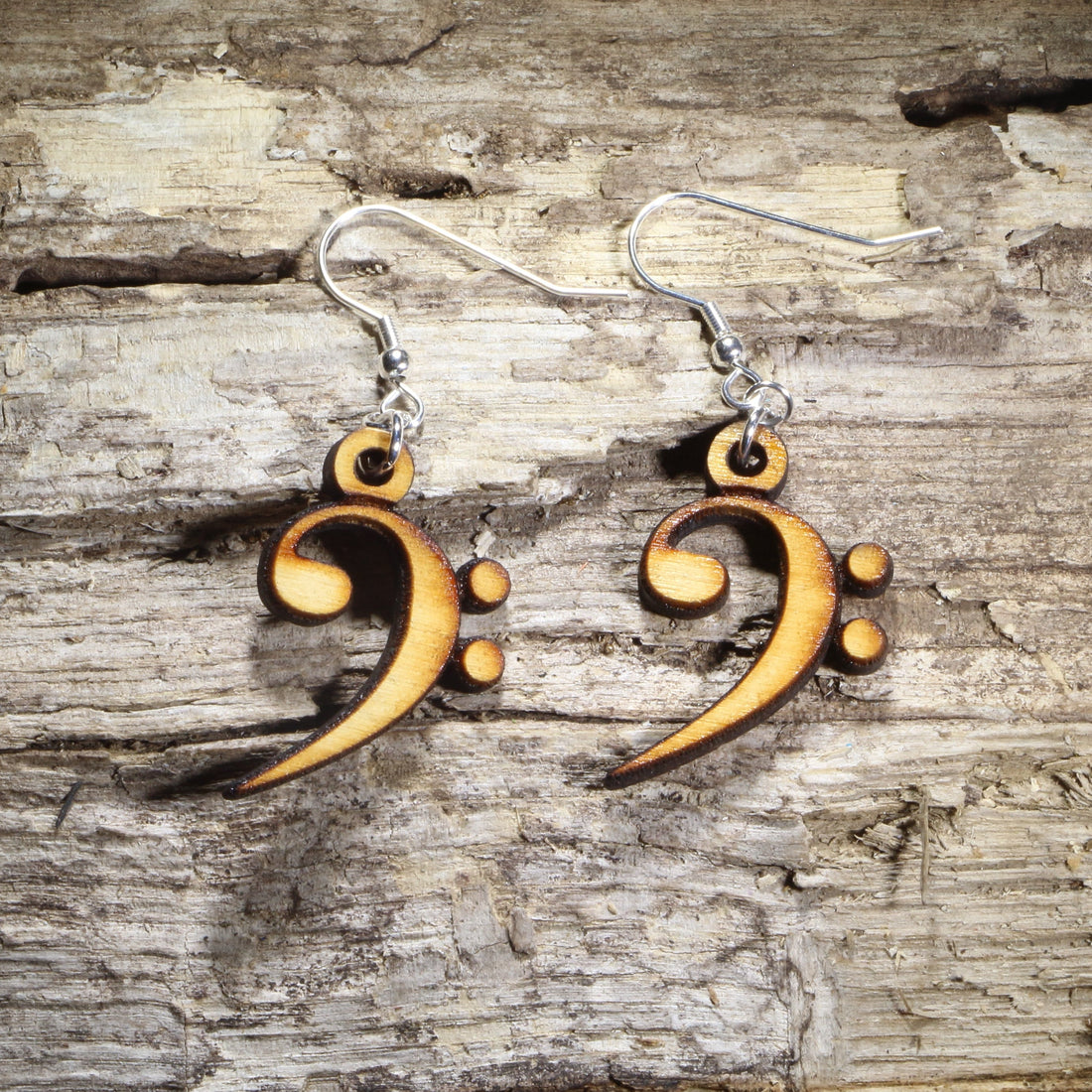Hand-painted wooden bass clef dangle earrings featuring the classic bass clef music symbol on hypoallergenic .925 sterling silver hooks. Lightweight music jewelry for bass players, choir members, band and orchestra musicians, music teachers, composers, and lovers of low brass, strings, and bass clef instruments.