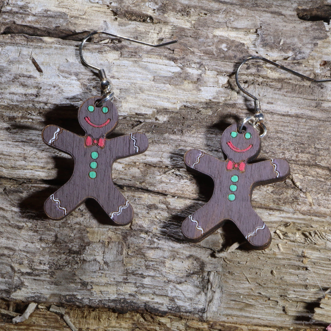 Hand-painted wooden chocolate gingerbread man dangle earrings with festive Christmas details. Lightweight holiday earrings featuring hypoallergenic .925 sterling silver hooks, perfect for Christmas parties, cookie exchanges, winter celebrations, and seasonal gift giving.
