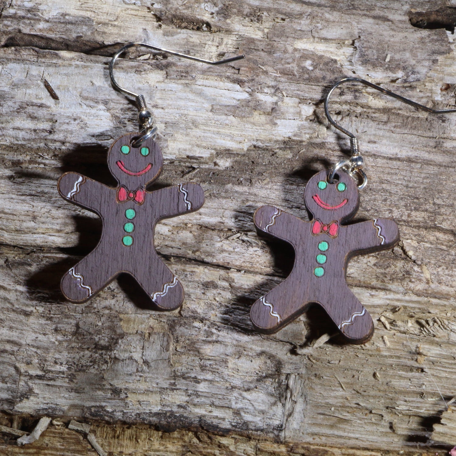 Hand-painted wooden chocolate gingerbread man dangle earrings with festive Christmas details. Lightweight holiday earrings featuring hypoallergenic .925 sterling silver hooks, perfect for Christmas parties, cookie exchanges, winter celebrations, and seasonal gift giving.