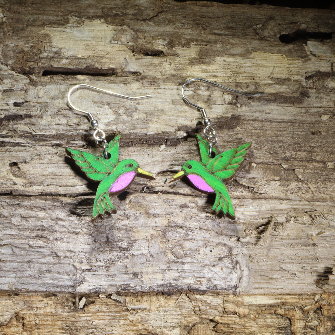 Hand-painted wooden hummingbird dangle earrings featuring vibrant green feathers, purple chest accents, and yellow beaks on hypoallergenic .925 sterling silver hooks. Lightweight bird-inspired jewelry for hummingbird lovers, bird watchers, gardeners, nature enthusiasts, and wildlife gifts.