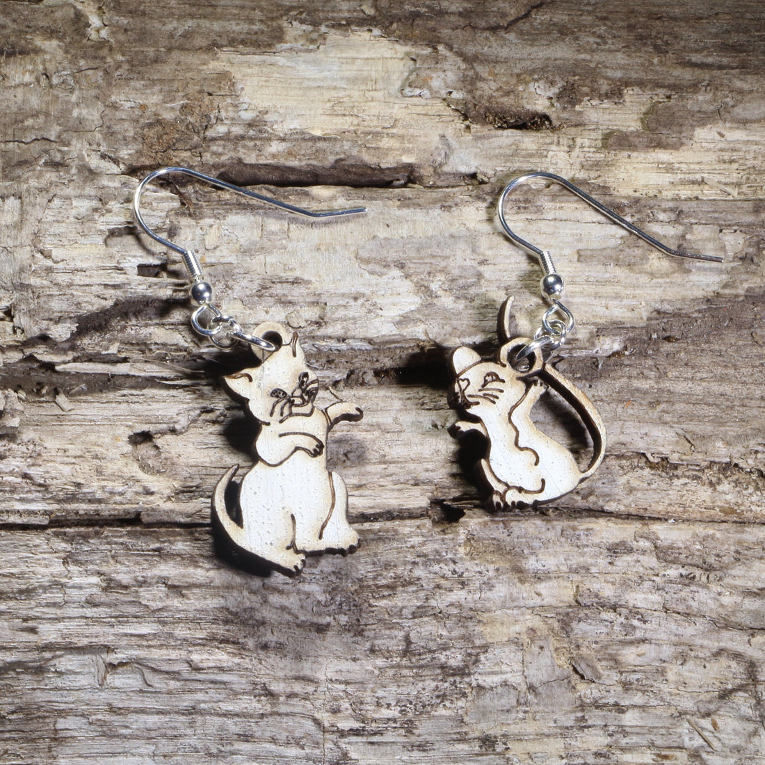 Hand-painted wooden mismatched cat and mouse dangle earrings featuring a playful white cat reaching toward a smiling mouse on hypoallergenic .925 sterling silver hooks. Lightweight animal jewelry for cat lovers, mouse enthusiasts, pet owners, and anyone who enjoys whimsical, playful accessories.