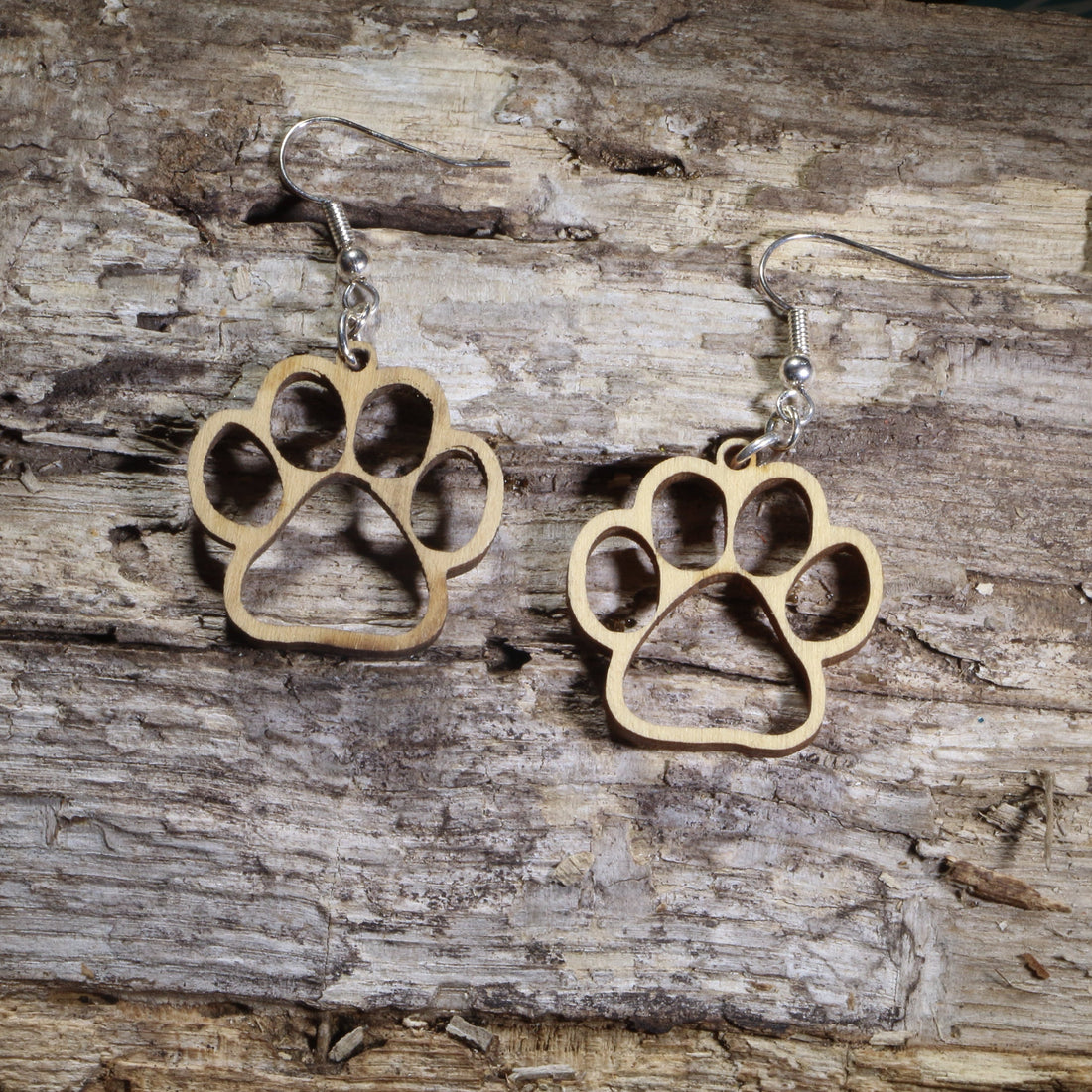 Hand-painted wooden open paw print dangle earrings featuring an outlined paw print cutout design on hypoallergenic .925 sterling silver hooks. Lightweight pet lover jewelry for dog lovers, cat lovers, veterinarians, veterinary technicians, animal rescue supporters, and pet parents.