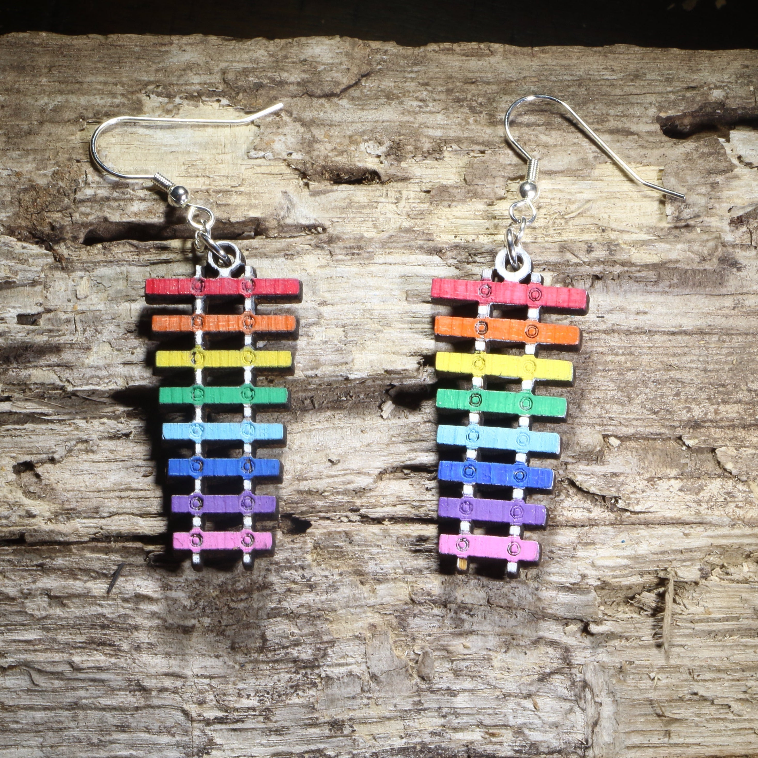 Hand-painted wooden rainbow xylophone dangle earrings featuring colorful xylophone bars on hypoallergenic .925 sterling silver hooks. Lightweight music-inspired jewelry for musicians, music teachers, percussionists, band members, orchestra students, and Pride supporters.