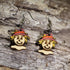 Hand-painted wooden scarecrow dangle earrings featuring smiling scarecrow faces with straw hair and burgundy hats on hypoallergenic .925 sterling silver hooks. Lightweight fall harvest jewelry perfect for autumn lovers, Halloween, and Thanksgiving.