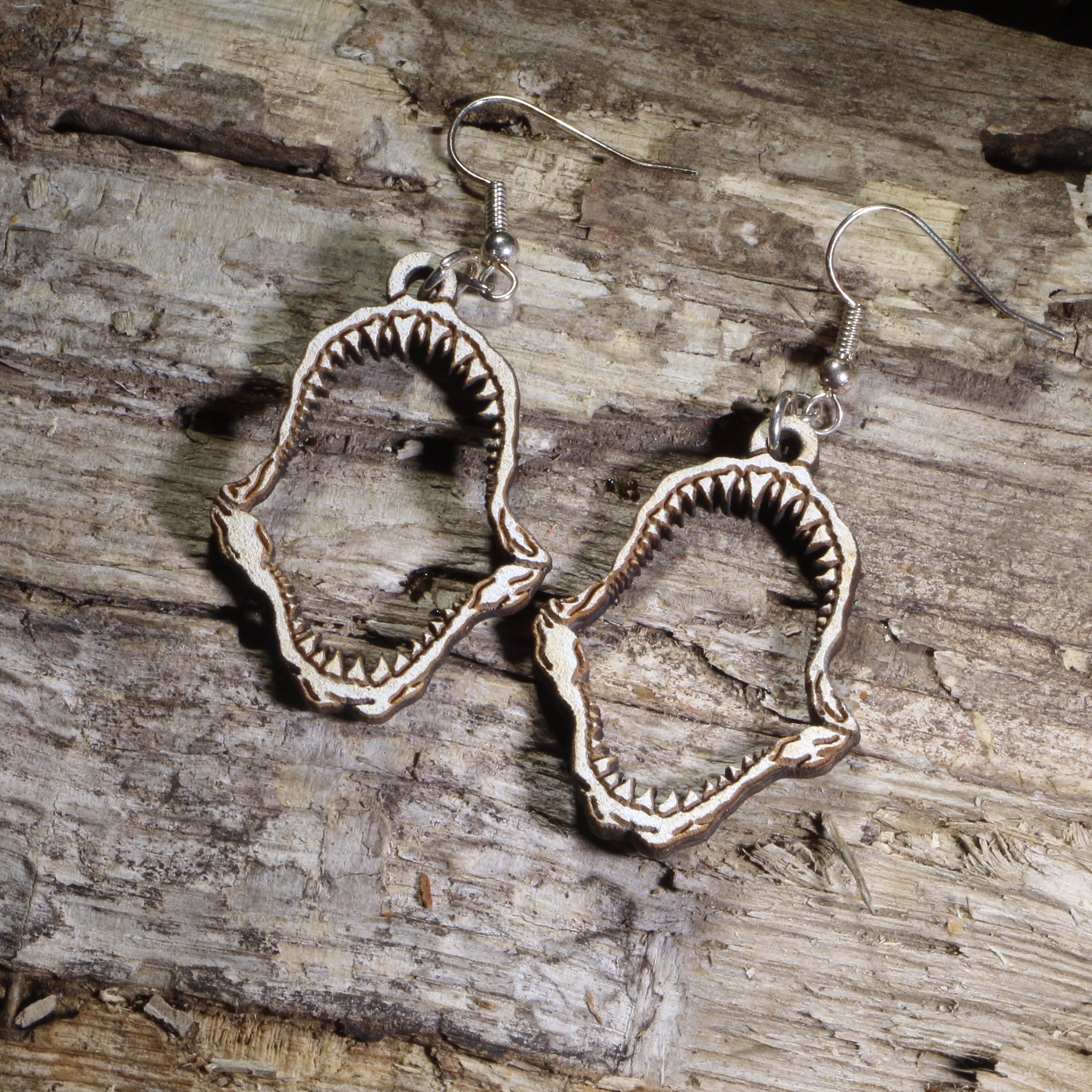 Hand-painted wooden shark jaw dangle earrings featuring detailed fossil-style shark jaws on hypoallergenic .925 sterling silver hooks. Lightweight ocean-inspired jewelry for shark lovers, marine biologists, beach enthusiasts, divers, and ocean wildlife fans.