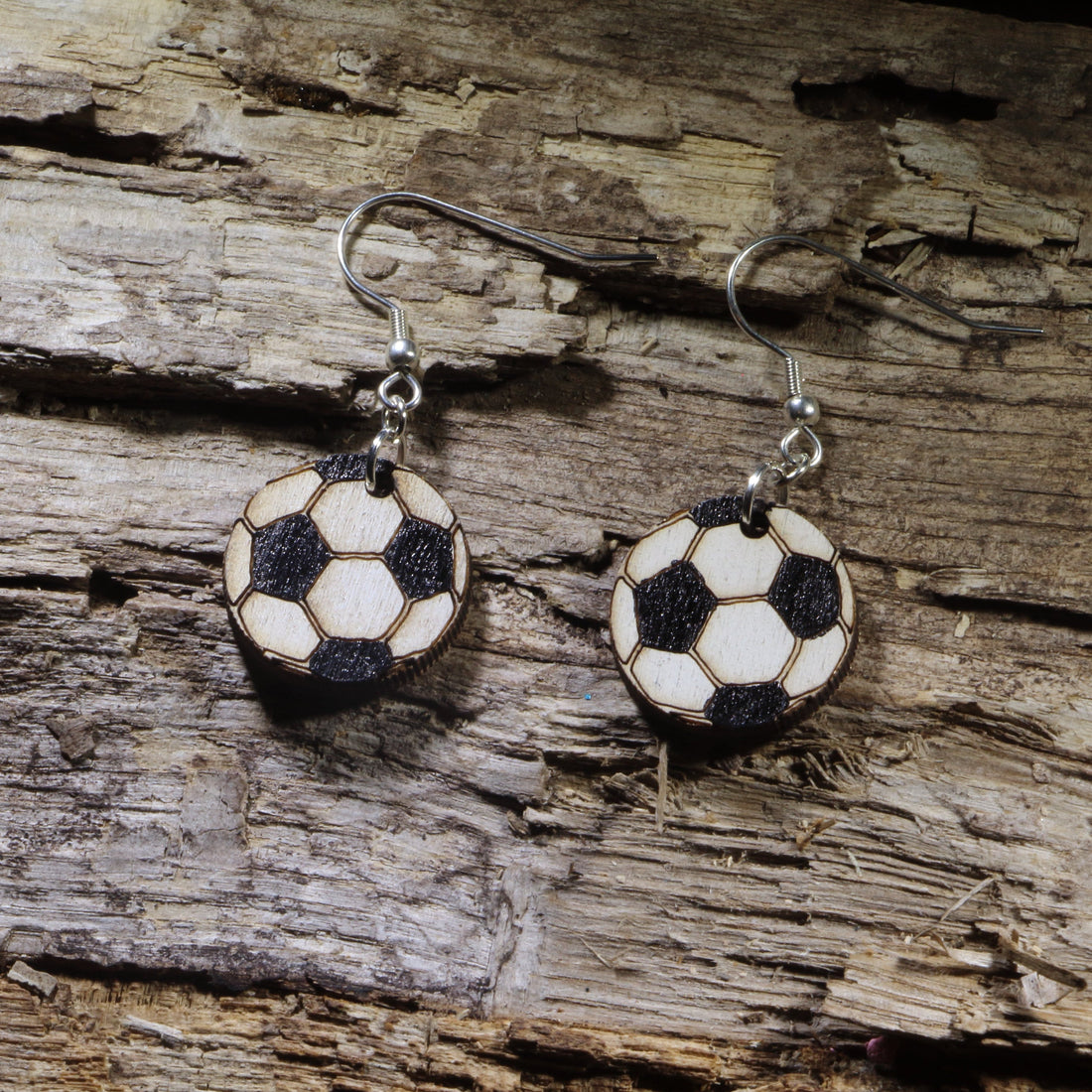 Hand-painted wooden soccer ball dangle earrings featuring the classic black-and-white soccer ball design. Lightweight sports earrings with hypoallergenic .925 sterling silver hooks, perfect for soccer players, coaches, referees, team moms, sports fans, and anyone who loves the world&