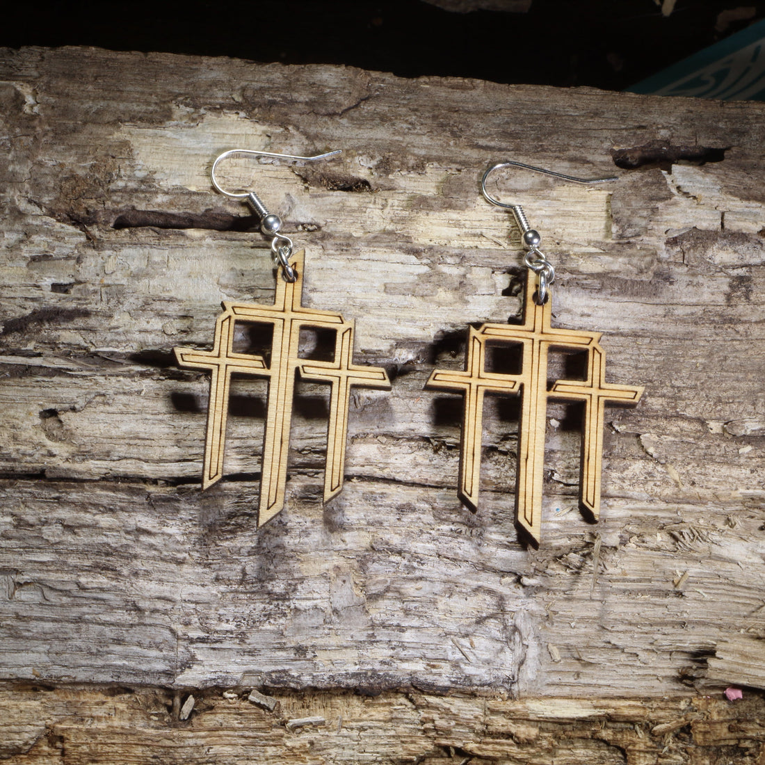 Hand-painted wooden triple cross dangle earrings featuring three Christian crosses symbolizing the crucifixion of Jesus on hypoallergenic .925 sterling silver hooks. Lightweight Christian faith jewelry for church services, Easter, pastors, Bible study groups, and believers who want to express their faith.