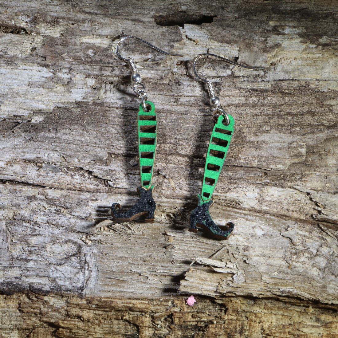 Hand-painted wooden witch legs dangle earrings featuring striped stockings, pointed black witch shoes, and a whimsical Halloween design. Lightweight Halloween earrings with hypoallergenic .925 sterling silver hooks, perfect for spooky season, Halloween parties, witch lovers, trick-or-treat events, and festive fall outfits.