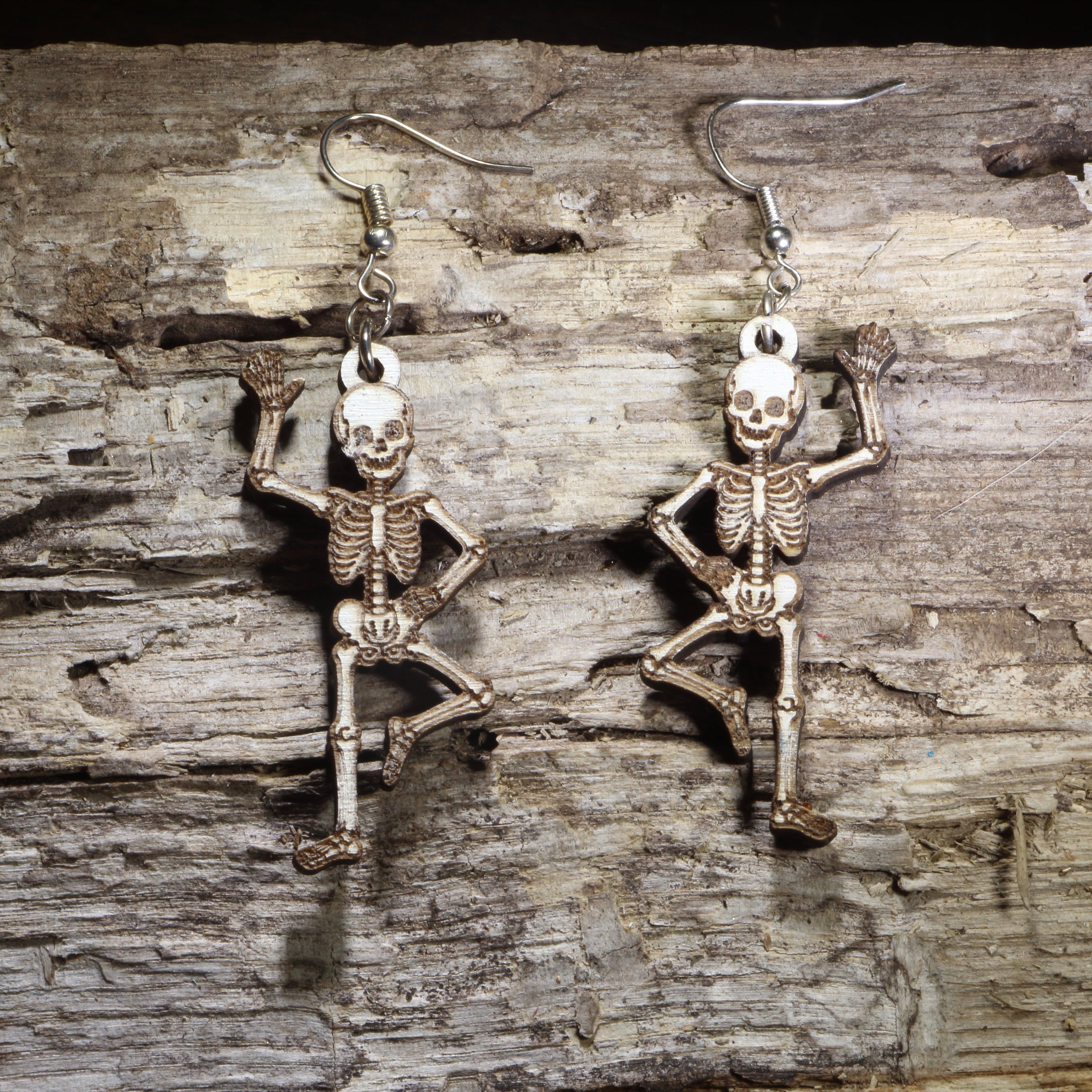 Handcrafted Dancing Skeleton wooden dangle earrings featuring a playful full-body skeleton in a dancing pose. Lightweight laser-cut wooden earrings with hypoallergenic .925 sterling silver hooks, perfect for Halloween lovers, anatomy enthusiasts, gothic fashion, spooky season, Day of the Dead celebrations, and skeleton jewelry collectors.