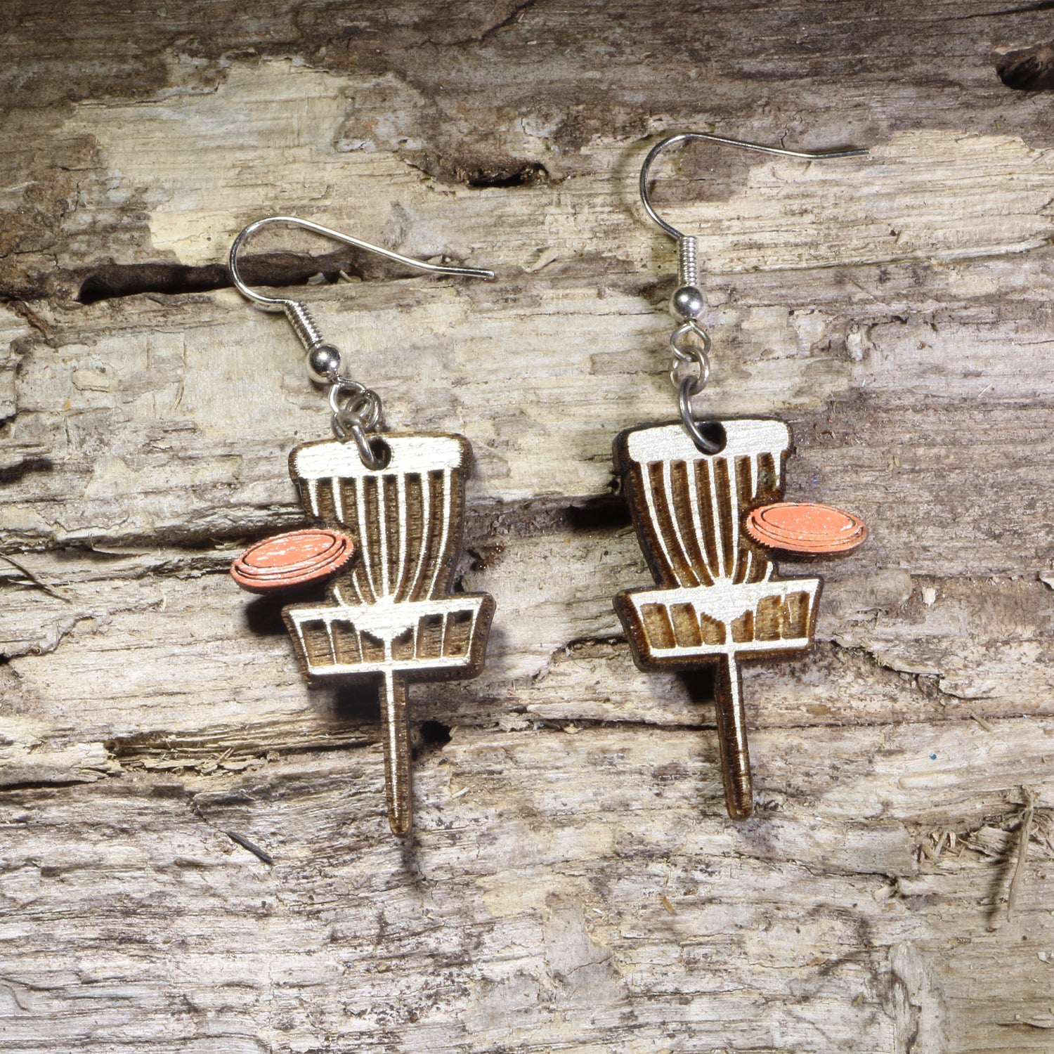 Handcrafted Disc Golf Basket wooden dangle earrings featuring a disc golf target basket with an orange flying disc. Lightweight laser-cut wooden earrings with hypoallergenic .925 sterling silver hooks, perfect for disc golf players, frisbee golf enthusiasts,  outdoor sports lovers, and unique sports jewelry.