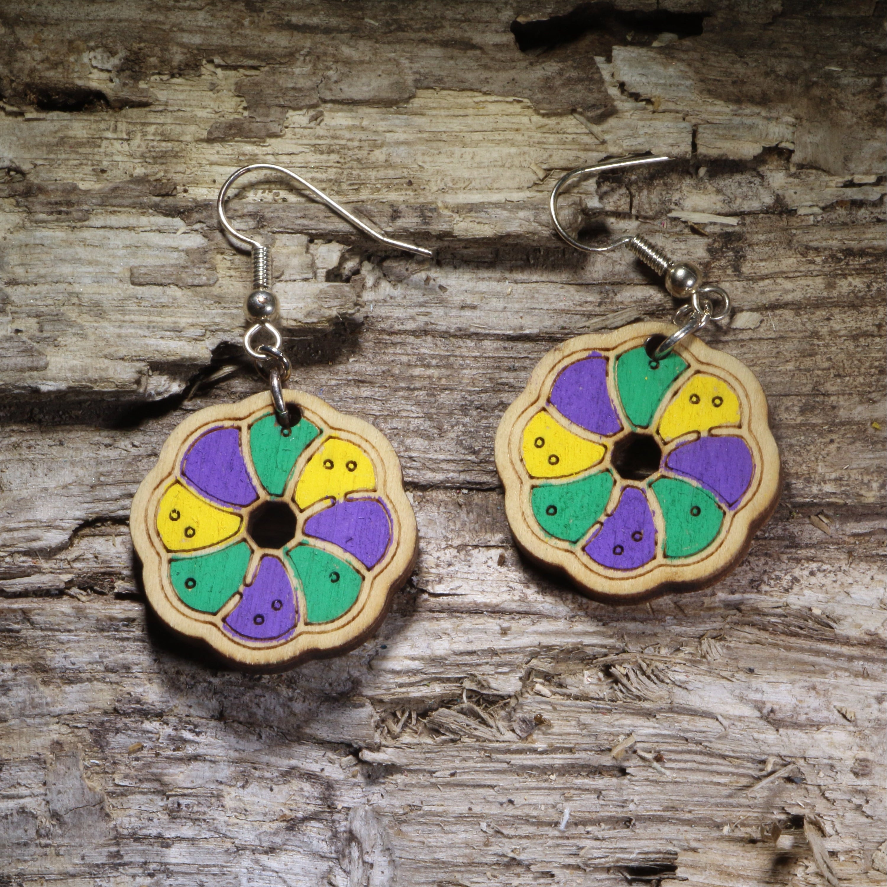 Handcrafted King Cake wooden dangle earrings featuring a colorful Mardi Gras king cake slice design in traditional purple, green, and gold. Lightweight laser-cut wooden earrings with hypoallergenic .925 sterling silver hooks, perfect for Mardi Gras celebrations, Fat Tuesday, New Orleans festivals, Louisiana pride, bakeries, and handmade festive jewelry.