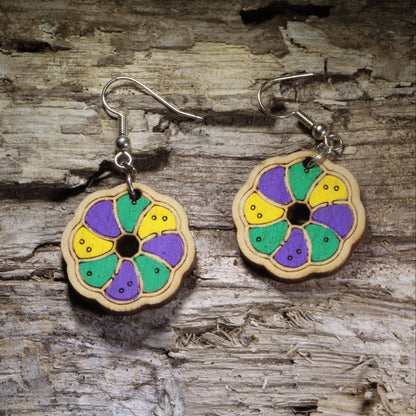Handcrafted King Cake wooden dangle earrings featuring a colorful Mardi Gras king cake slice design in traditional purple, green, and gold. Lightweight laser-cut wooden earrings with hypoallergenic .925 sterling silver hooks, perfect for Mardi Gras celebrations, Fat Tuesday, New Orleans festivals, Louisiana pride, bakeries, and handmade festive jewelry.