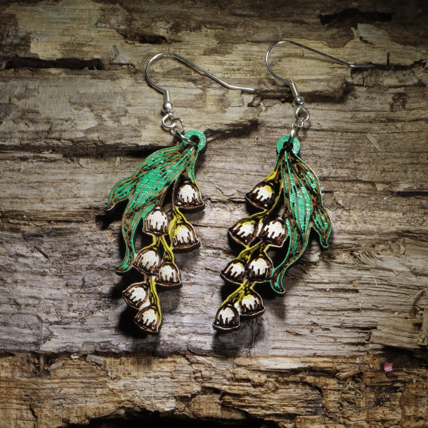 Handcrafted Lily of the Valley wooden dangle earrings featuring delicate white bell-shaped flowers with hand-painted green leaves. Lightweight laser-cut wooden earrings with hypoallergenic .925 sterling silver hooks, perfect for flower lovers, gardeners, spring fashion, botanical jewelry, birth flower gifts, and handmade floral earrings.