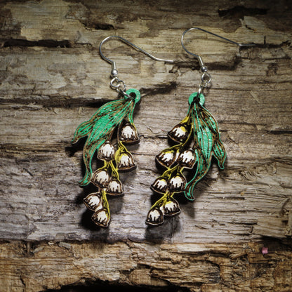 Handcrafted Lily of the Valley wooden dangle earrings featuring delicate white bell-shaped flowers with hand-painted green leaves. Lightweight laser-cut wooden earrings with hypoallergenic .925 sterling silver hooks, perfect for flower lovers, gardeners, spring fashion, botanical jewelry, birth flower gifts, and handmade floral earrings.