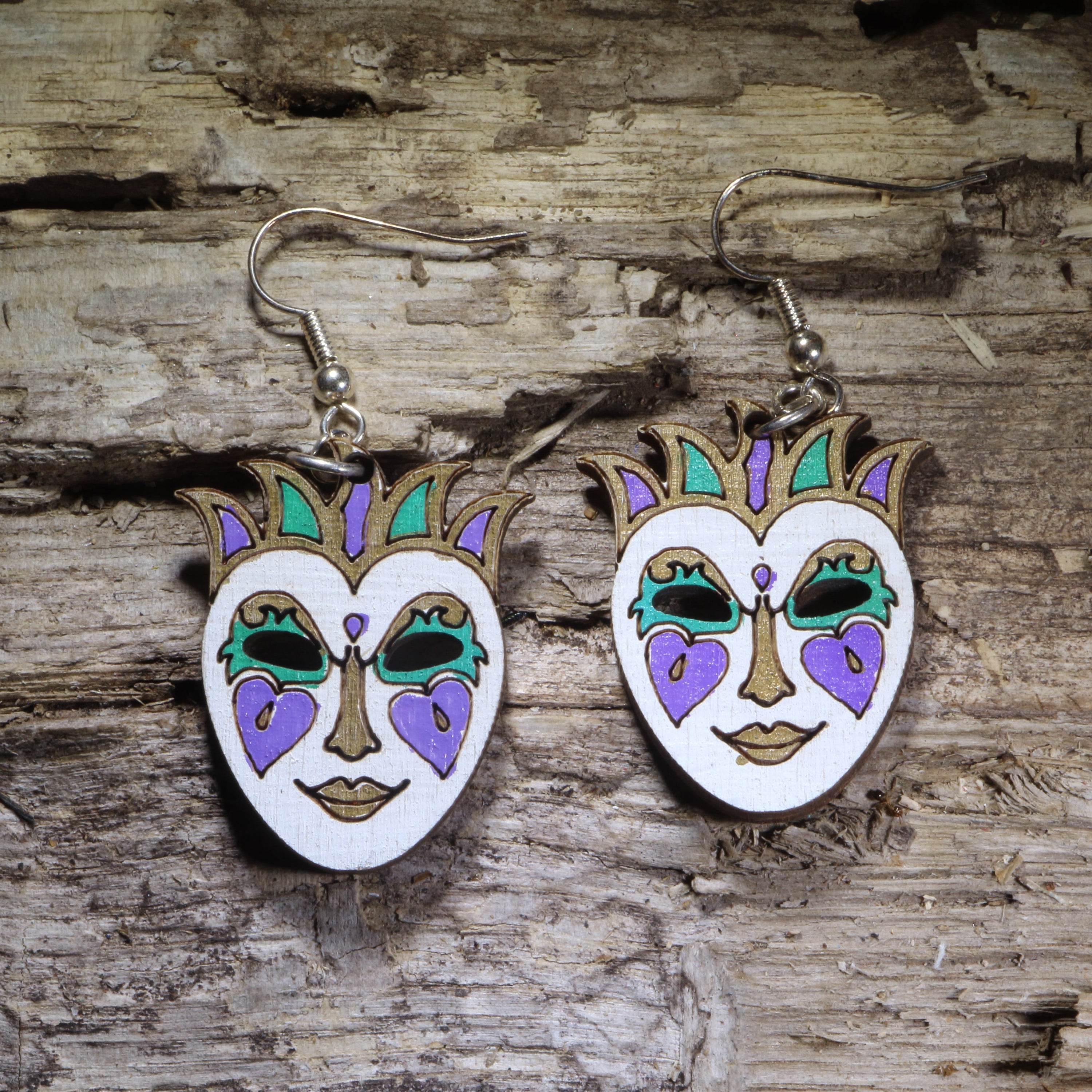 Handcrafted Mardi Gras mask wooden dangle earrings featuring an elegant carnival mask hand-painted in purple, green, gold, and white. Lightweight laser-cut wooden earrings with hypoallergenic .925 sterling silver hooks, perfect for Mardi Gras celebrations, New Orleans festivals, masquerade parties, carnival costumes, and festive handmade jewelry.