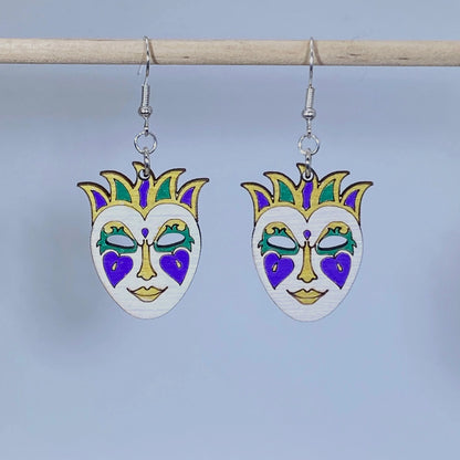 Handcrafted Mardi Gras mask wooden dangle earrings featuring a festive masquerade mask in traditional purple, green, gold, and white colors. Lightweight laser-cut wooden earrings with hypoallergenic .925 sterling silver hooks, perfect for Mardi Gras celebrations, New Orleans festivals, carnival parties, masquerade costumes, Louisiana gifts, and handmade festival jewelry.