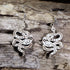 Handcrafted celestial snake wooden dangle earrings featuring engraved moon phases, stars, constellations, and botanical details. Lightweight wooden serpent earrings with hypoallergenic .925 sterling silver hooks, perfect for witchy jewelry lovers, celestial fashion, gothic style, and nature-inspired accessories.