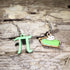 Handcrafted mismatched wooden dangle earrings featuring a bright green pi symbol and a slice of green key lime pie with whipped cream. Lightweight math and dessert earrings with hypoallergenic .925 sterling silver hooks, perfect for math teachers, STEM enthusiasts, pie lovers, and quirky geeky jewelry fans.