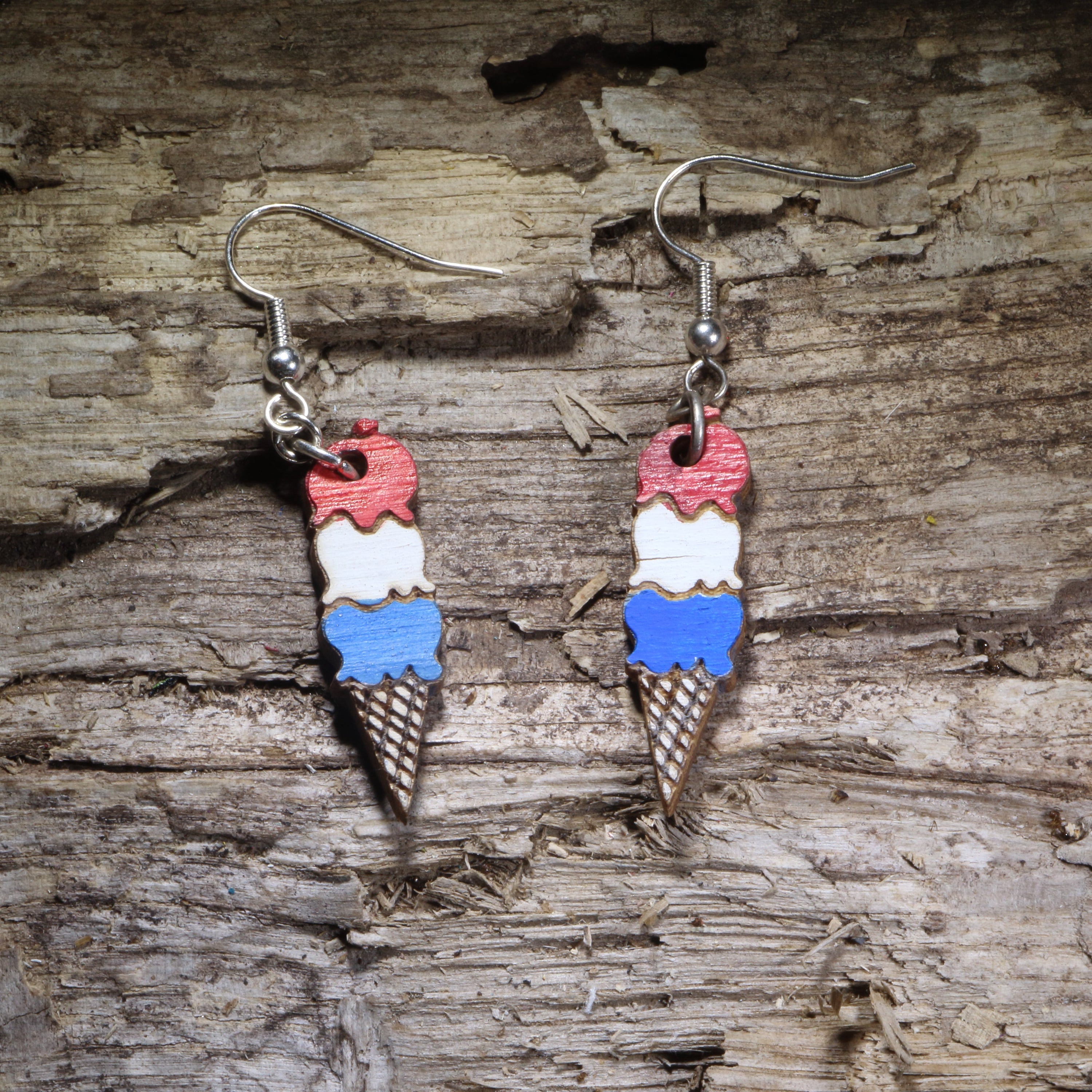 Handcrafted patriotic ice cream cone wooden dangle earrings featuring red, white, and blue scoops in a waffle cone. Lightweight laser-cut wooden earrings with hypoallergenic .925 sterling silver hooks, perfect for Fourth of July, Memorial Day, summer festivals, ice cream lovers, Americana fashion, and handmade patriotic jewelry.